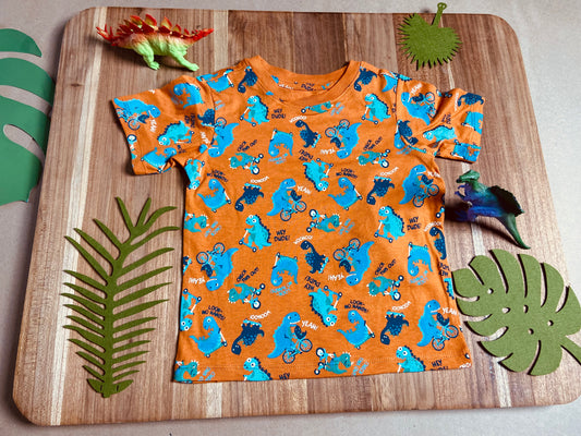 Camiseta naranja con dinos celestes